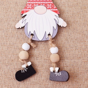 Close-up of wooden Christmas gnome ornament with jute rope legs and bead details