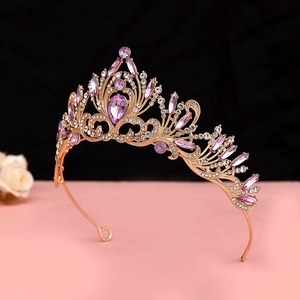 Close-up of rose gold baroque crown with purple rhinestones and intricate filigree details