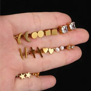 18K gold earring set featuring moon star and heart shapes worn on a hand model