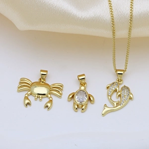 Gold-plated ocean theme necklaces featuring crab, turtle, and dolphin pendants on silk