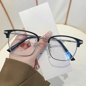 Detailed close-up of retro black and silver browline glasses with metallic bridge detail