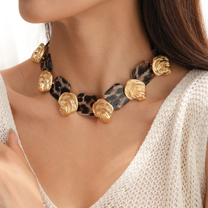 Detail of vintage leopard print resin beads and gold textured metal links on a necklace