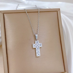 Close-up of titanium steel cross pendant with cubic zirconia in a jewelry box