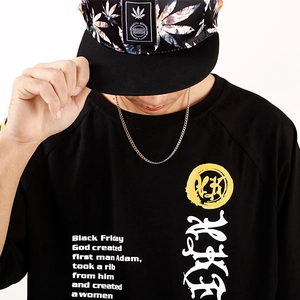 Gros plan d'une chaîne hip-hop en acier inoxydable avec un t-shirt noir graphique