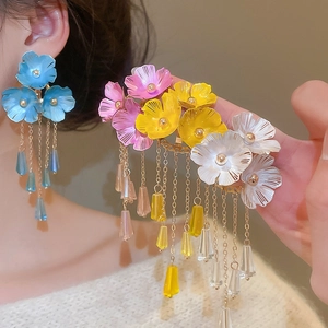 Detailansicht der Blumen-Ohrringe mit langen Quasten und Kristallanhängern am Ohr