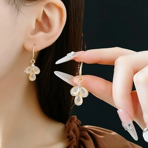 Detail of gold teardrop earrings with cat eye stones and sparkling crystal accents