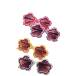 Children flower-shaped sunglasses in pink, purple, yellow, and white on white background