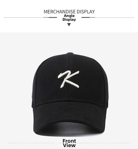 Detailed close-up of white letter K embroidery on a black cotton baseball cap