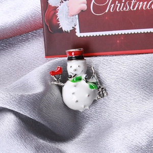 Vue macro d'une broche bonhomme de neige avec chapeau rouge et écharpe verte festive