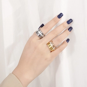 Detailed shot of multi-layered Roman numeral rings with crystal pave on a model hand