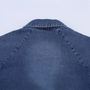 Deep blue wash denim cape jacket showing detailed stitching on collar and shoulder area