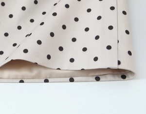 Gros plan de l'ourlet du blazer à pois avec doublure douce et texture tissée