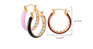 Macro detail of gold plated hoop earrings with pink enamel and white zircon stones