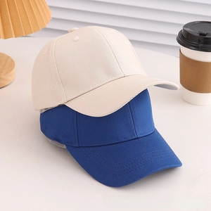 Classic beige and royal blue baseball caps in thick twill cotton on a white surface
