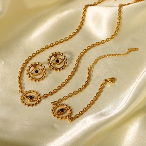 Gros plan détaillé de la parure de bijoux œil grec doré sur tissu en soie