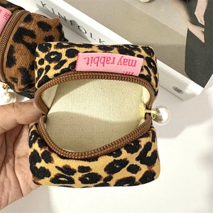 Detail of leopard print corduroy earphone pouch with zipper and pearl pendant decoration