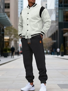 Detail of light grey and black baseball jacket and joggers set in an urban street setting