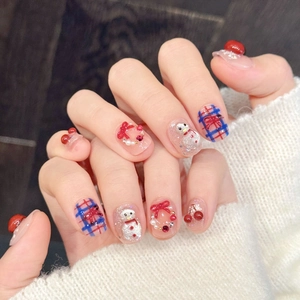 Close-up of festive press-on nails with 3D snowman and cherry designs on a knit sweater