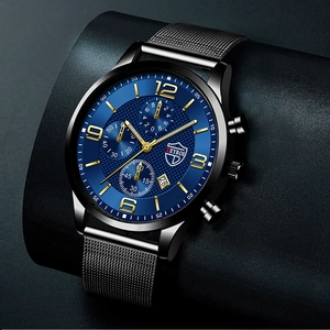 Detail of blue dial quartz watch with black mesh strap and luminous calendar display