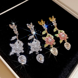 Dettaglio ravvicinato di orecchini a fiore scintillanti con strass su velluto nero