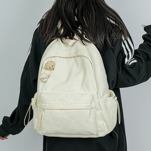 Weißer Cord-Rucksack für Damen mit Teddybär-Ansteckern in der Rückansicht am Model