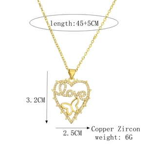 Close-up of gold heart pendant necklace with love lettering and butterfly details