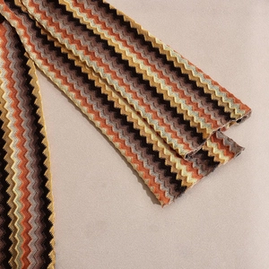 Detailed close-up of the zigzag knit texture on a V-neck dress in warm autumn tones