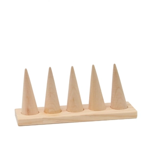 Minimalist wooden ring display stand with five conical holders on a rectangular base