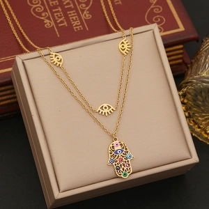 Golden double layer necklace featuring evil eye charms and a Hamsa hand pendant jewelry