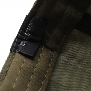 Detail view of cotton washing label and inner stitching on camo military flat top cap