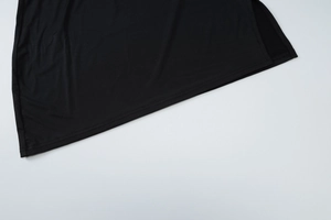 Close-up of the black knitted fabric texture and fine stitching on the mini skirt hem