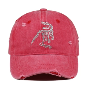 Close-up of pink distressed baseball cap featuring silver dinosaur skeleton embroidery