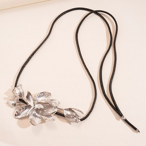 Gros plan d'un pendentif fleur de tulipe en métal brossé sur un cordon en cuir noir