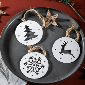 White metal Christmas ornaments with deer and snowflake patterns on a rustic plate