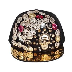 Hip hop snapback hat featuring a gold skull, studs, and reflective golden flat brim