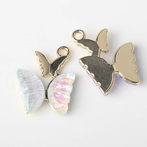 Macro detail of iridescent butterfly charms with gold metal base for DIY jewelry