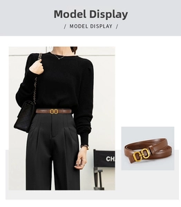 Detail of slim dark brown leather belt with gold double-ring buckle on black trousers