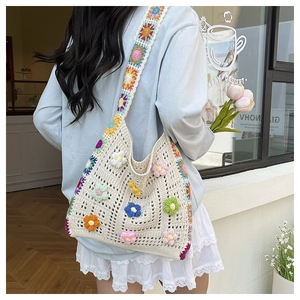 Detailed close-up of a crochet floral shoulder bag with a wide sunflower strap and 3D flowers