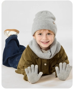 Detalle del conjunto de punto gris con gorro, bufanda y guantes para niños en invierno