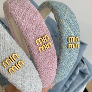 Tre cerchietti imbottiti in tweed bianco, rosa e blu con dettagli logo in metallo