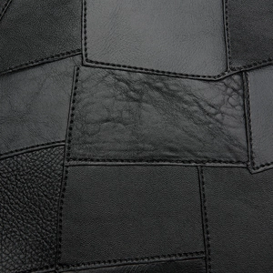 Macro shot of black leather patchwork design with detailed stitching on women's backpack
