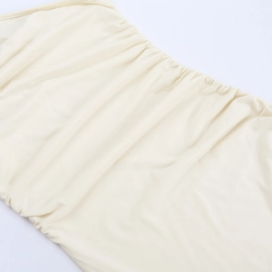 Close-up detail of the cream-white ruffled fabric and pleated texture on this summer dress