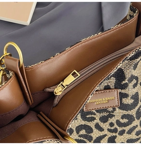 Detailed close-up of leopard print fabric and brown leather panel on a tote bag