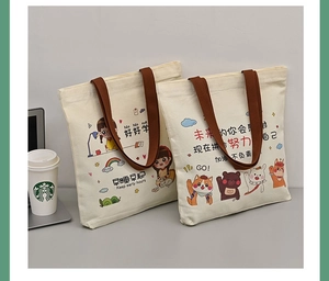 Close-up of durable canvas tote bags with cartoon illustrations and reinforced brown handles