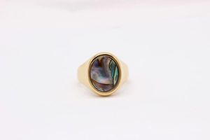 Macro detail of oval abalone shell inlay on vintage gold-plated titanium steel ring