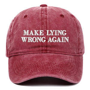 Close-up of white 3D embroidery text on washed burgundy cotton baseball cap