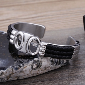 Détail macro du bracelet C pour hommes en acier argenté avec incrustation en cuir tressé
