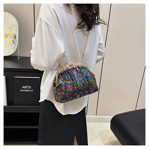 Detail shot of multi-color sequin shell bag with gold chain strap on a model shoulder