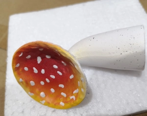 Detailed shot of a red mushroom hanging shelf with white spots and realistic resin texture