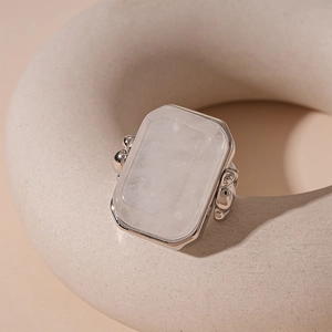 Detailed macro view of a rectangular moonstone ring on a minimalist ceramic pedestal